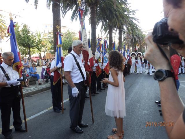 Un membre du conseil municipal de la Ville remet la médaille à un porte-drapeau