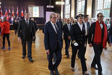 Les personnalités officielles et le public suivent les pompiers.