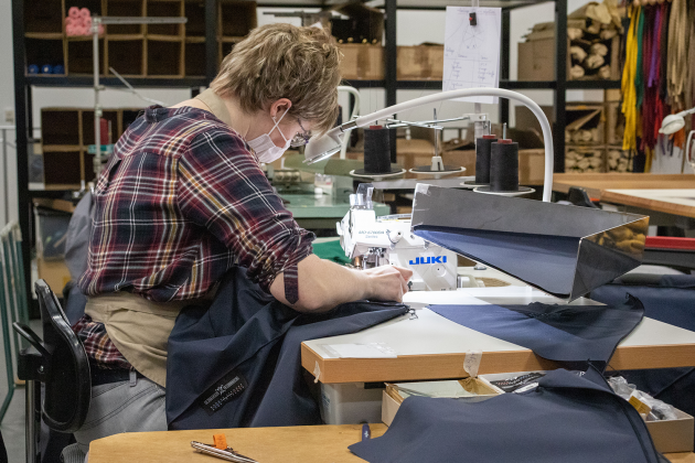 Une couturière assemble les pans de tissu pour former le parapluie.