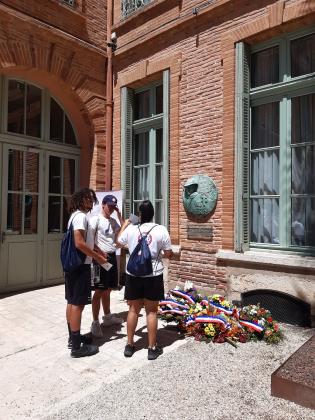 Des jeunes volontaires devant la stèle Jean Moulin